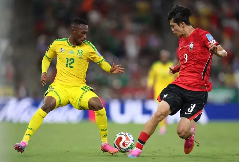 Em jogo da Copa do Mundo, jogador da Coreia do Sul disputa bola com atleta da África do Sul (Foto: Fifa)