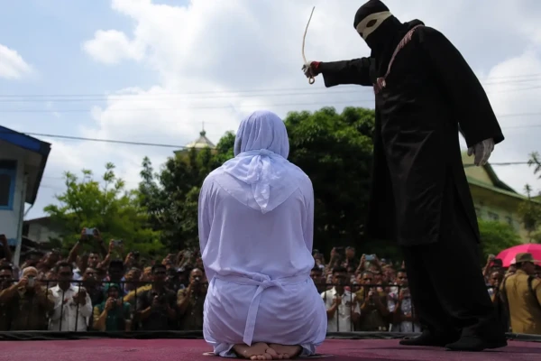 Condenada chegou a desmaiar em praça pública na Indonésia Mulher leva chibatadas após beijar homem em live no TikTok veja fotos