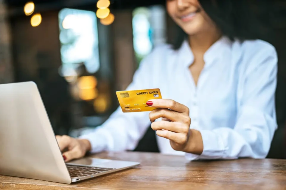 woman-sat-with-laptop-paid-with-credit-card-cafe