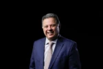 Ex-governador Marconi Perillo, à frente de um fundo preto, sorri para foto (Foto: Divulgação)