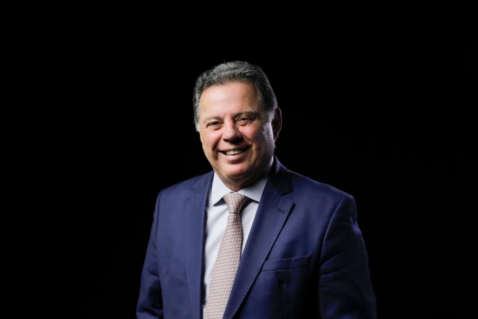 Ex-governador Marconi Perillo, à frente de um fundo preto, sorri para foto (Foto: Divulgação)