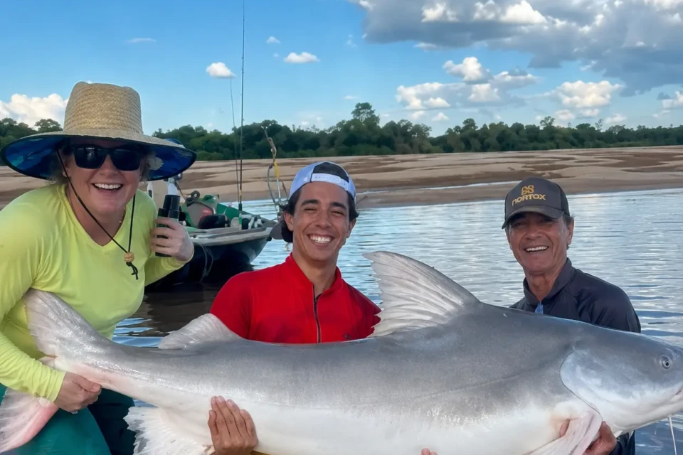 Pescadores exibem piraíba de aproximadamente dois metros capturada no Rio Araguaia, na região de São José dos Bandeirantes. O registro ganhou repercussão nas redes sociais pelo tamanho do peixe. Crédito: Reprodução/Redes Sociais.