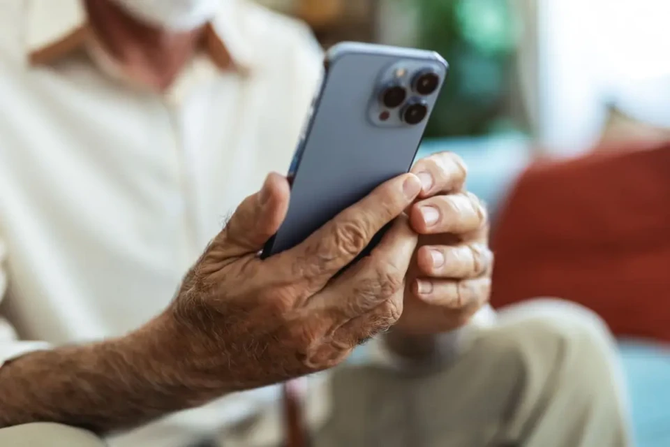 idoso segurando um celular nas mãos