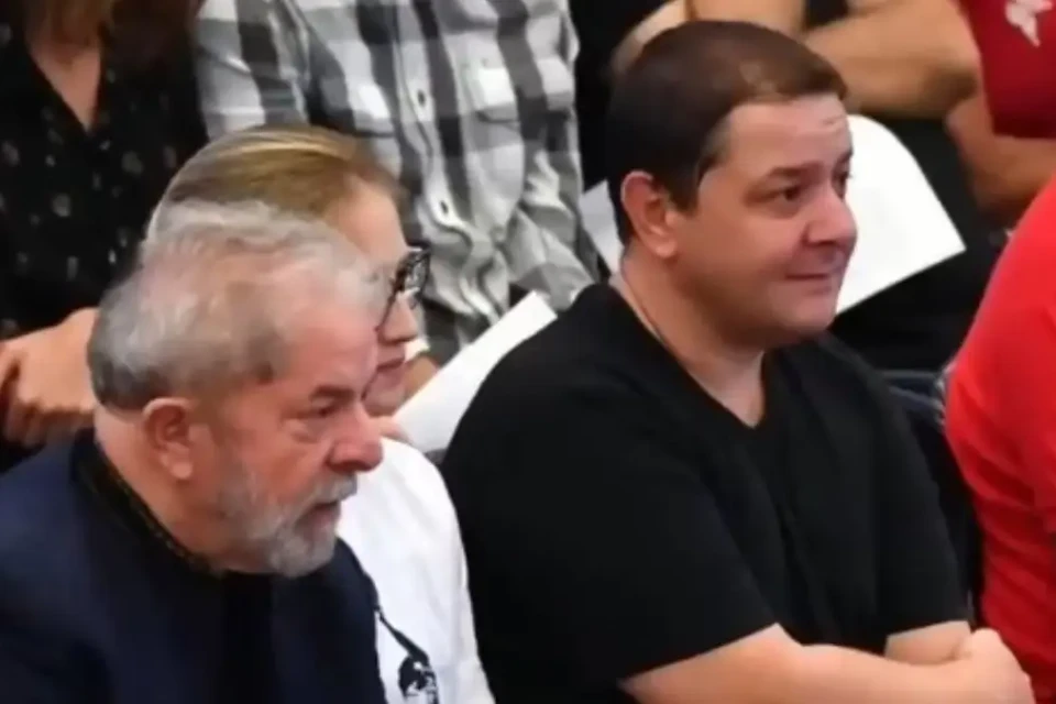 Presidente Lula sentado ao lado do filho dele, Lulinha