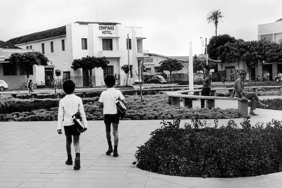 Vista histórica da Praça Coronel Joaquim Lúcio, em Campinas, com o antigo Campinas Hotel ao fundo e crianças circulando pelo local. Foto: Acervo da Prefeitura de Goiânia. 