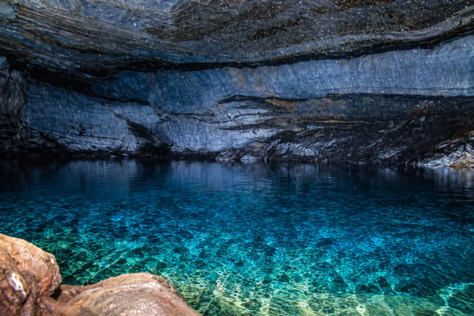 Lago subterrâneo da Gruta dos Ecos, em Cocalzinho de Goiás, destaca a transparência da água e as formações rochosas da cavidade. (Foto: Governo de Goiás)