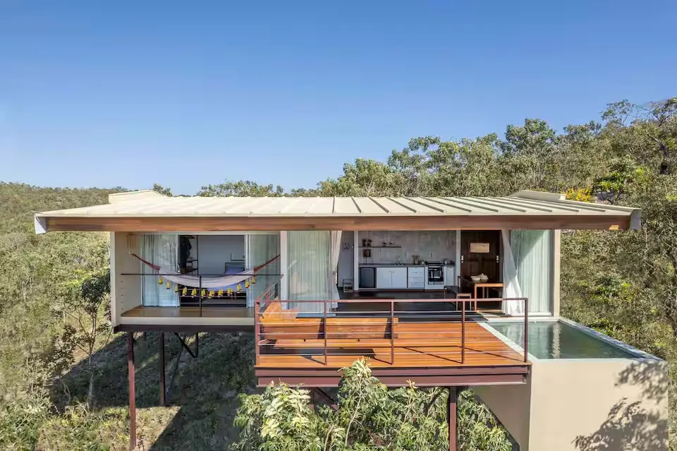 Casa Ipê, na Vila de São Jorge, aposta em arquitetura contemporânea integrada ao Cerrado, com grandes áreas de vidro, deck e piscina privativa em meio à vegetação da Chapada dos Veadeiros. (Foto: Reprodução/Airbnb)
