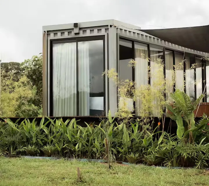 Summer Glass, em Pirenópolis, combina vidro e madeira em uma construção integrada ao Cerrado, com deck, ofurô ao ar livre e vista para as serras da região. (Foto: Reprodução/Airbnb)