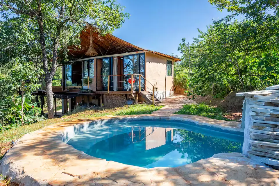 Cabana do Tatu, em Alexânia, fica às margens do Lago Corumbá IV e oferece piscina aquecida, acesso ao lago e proximidade com cachoeira, em um cenário marcado pela água e pelo Cerrado. (Foto: Reprodução/Airbnb)