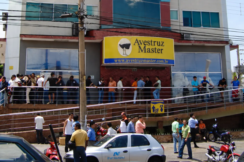 Investidores se concentram em frente a uma unidade da Avestruz Master durante a crise que antecedeu o colapso do grupo, em 2005. Sediada em Goiânia, a empresa atraiu mais de 40 mil pessoas para operações envolvendo a compra e recompra de avestruzes. (Foto: Acervo/MPF)
