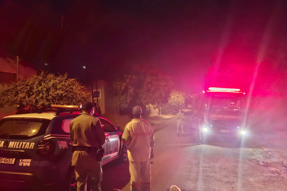 Foto colorida mostra viaturas da PMGO e Bombeiros em frente à casa de suspeito de incendiar área de vegetação em Jataí