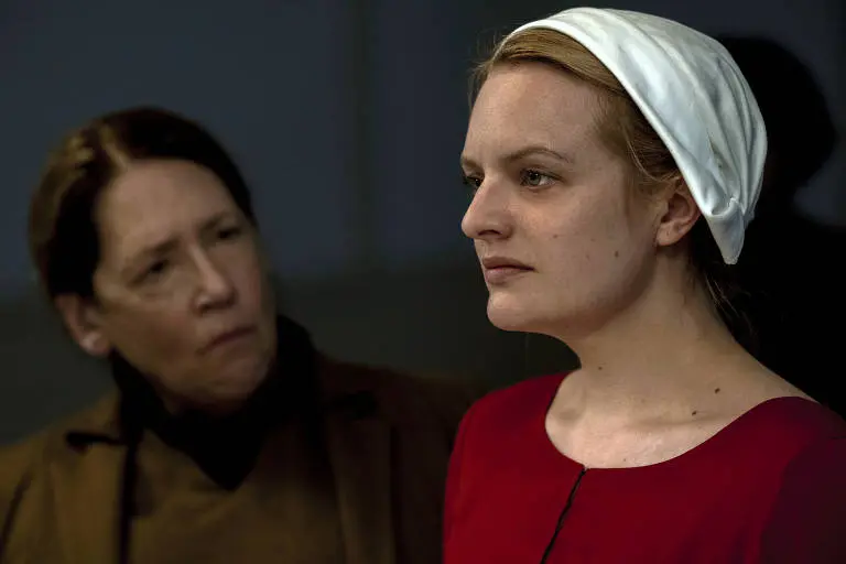 Cena de O Conto da Aia mostra uma das Aias sob supervisão dentro da estrutura de Gilead (Foto: Disney/Hulu)
