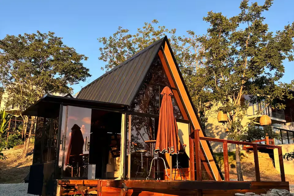Piribless Chalés – Oásis, em Pirenópolis, fica a cerca de cinco minutos do Centro Histórico e conta com arquitetura A-frame, fachada envidraçada, jacuzzi interna e área externa com rede suspensa (Foto: Reprodução/Airbnb)