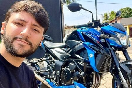 Mateus Henrique posa ao lado da motocicleta destruída após pegar fogo em acidente em Itaberaí