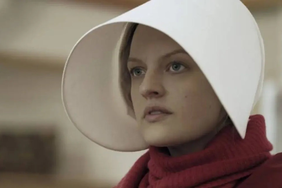 Personagem central de O Conto da Aia aparece com o traje vermelho e a touca branca que marcam a identidade visual das Aias em Gilead (Foto: Disney/Hulu)