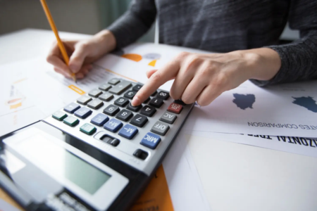 Homem faz contas com auxílio de calculadora