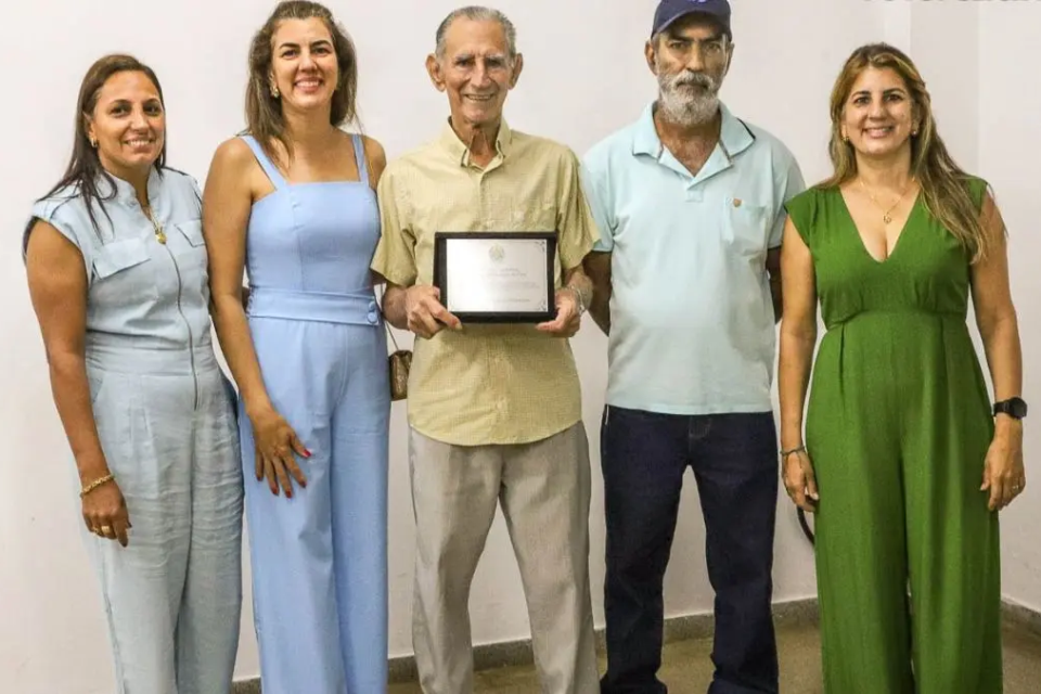 Homem posa ao lado dos filhos em Pirenópolis, em registro da família que mantém a tradição da tecelagem