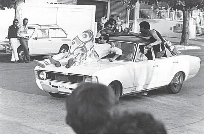 Jovens reunidos em torno de um automóvel durante movimentação nas ruas de Goiânia, em registro que retrata os costumes e a juventude de outras décadas (Foto: Acervo do Museu da Imagem e do Som de Goiás — MIS)