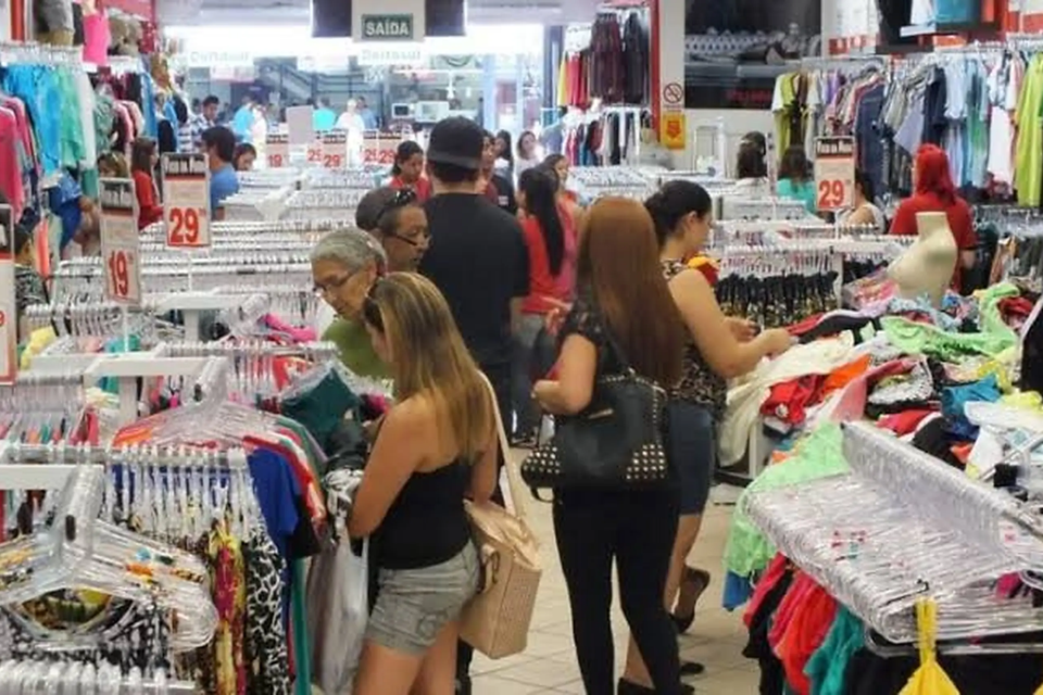 Consumidores pesquisam roupas e comparam preços em loja do comércio varejista (Foto: Reprodução)