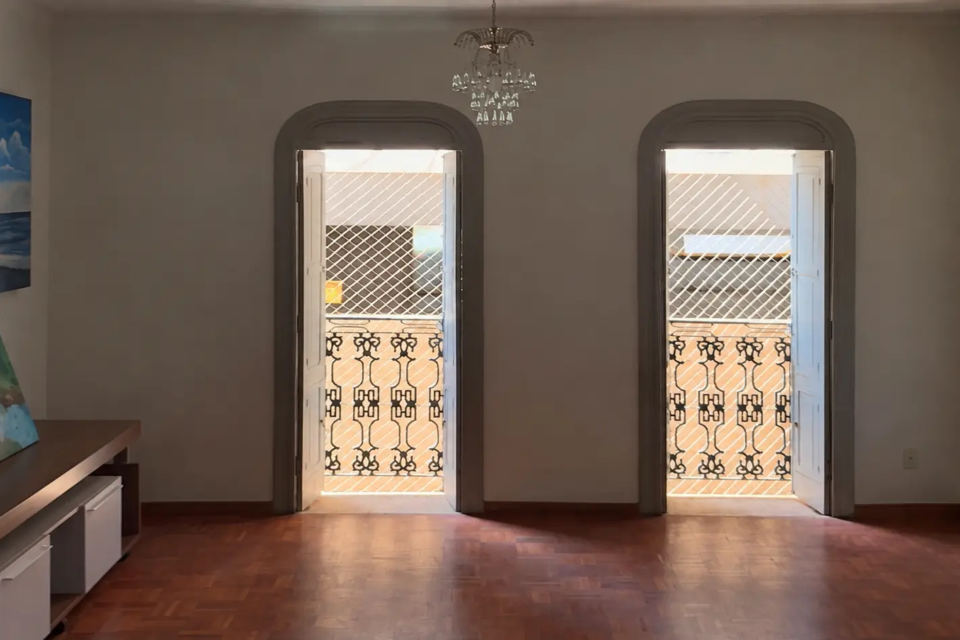 Sala do Residencial Vila Rica, no Setor Oeste, em Goiânia, preserva piso de madeira, portas em arco e sacadas com grades de ferro trabalhado (Foto: Reprodução/Instagram @franciscojunior_corretor)